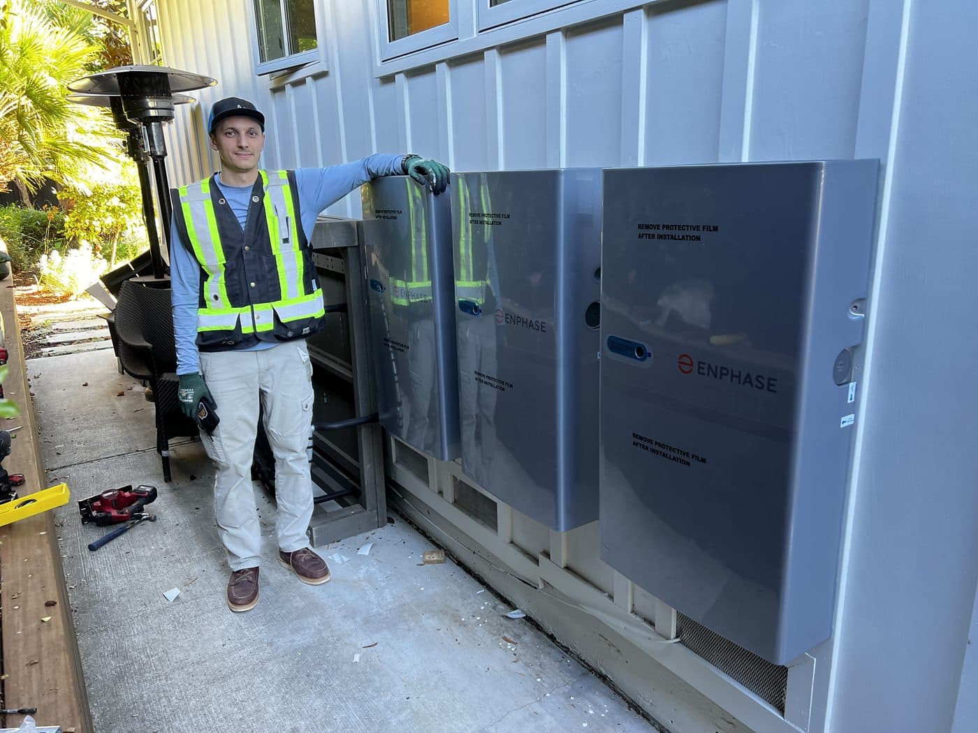 Tim next to a three-battery backup system